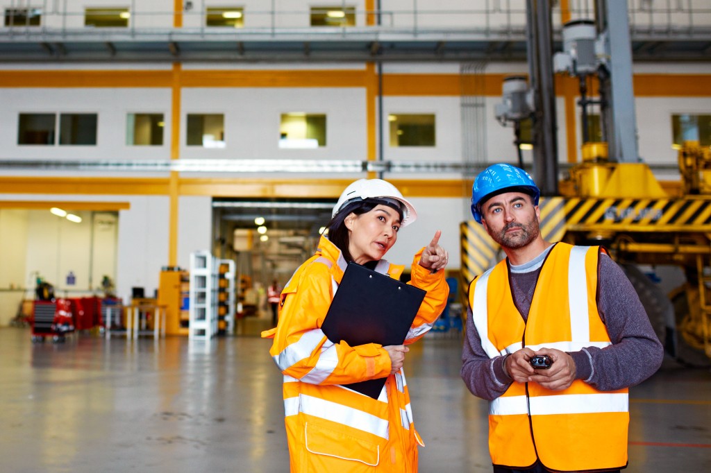 Ausbilderin erklärt einem Teilnehmer, wie Arbeitsschutz funtioniert.