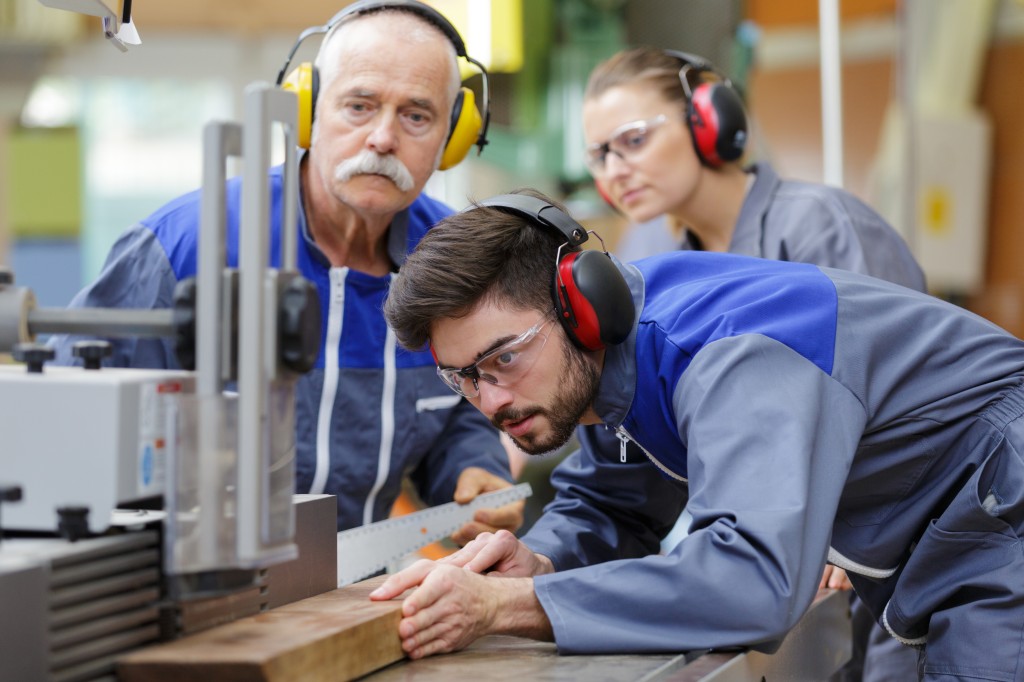Teilnehmende erledigen Aufgaben in ihrer geförderten Weiterbildung in Technik, Handwerk und Industrie.