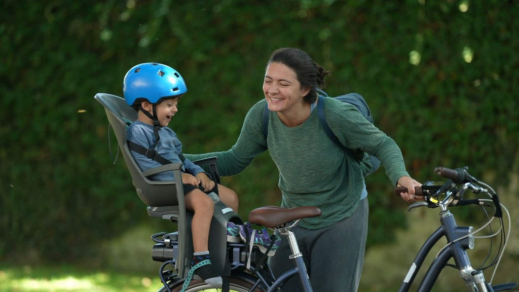 Mutter mit Kind im Fahrradkindersitz.