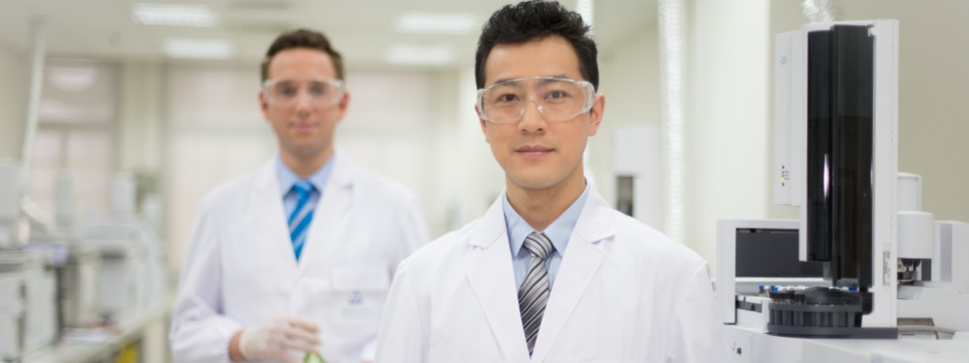 白衣を着て試験所に立っている男性社員