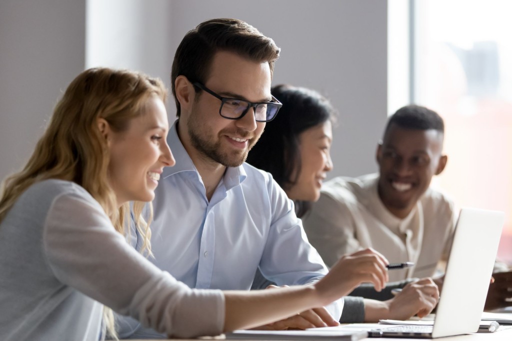 ラップトップを使いながら協力して作業をする同僚