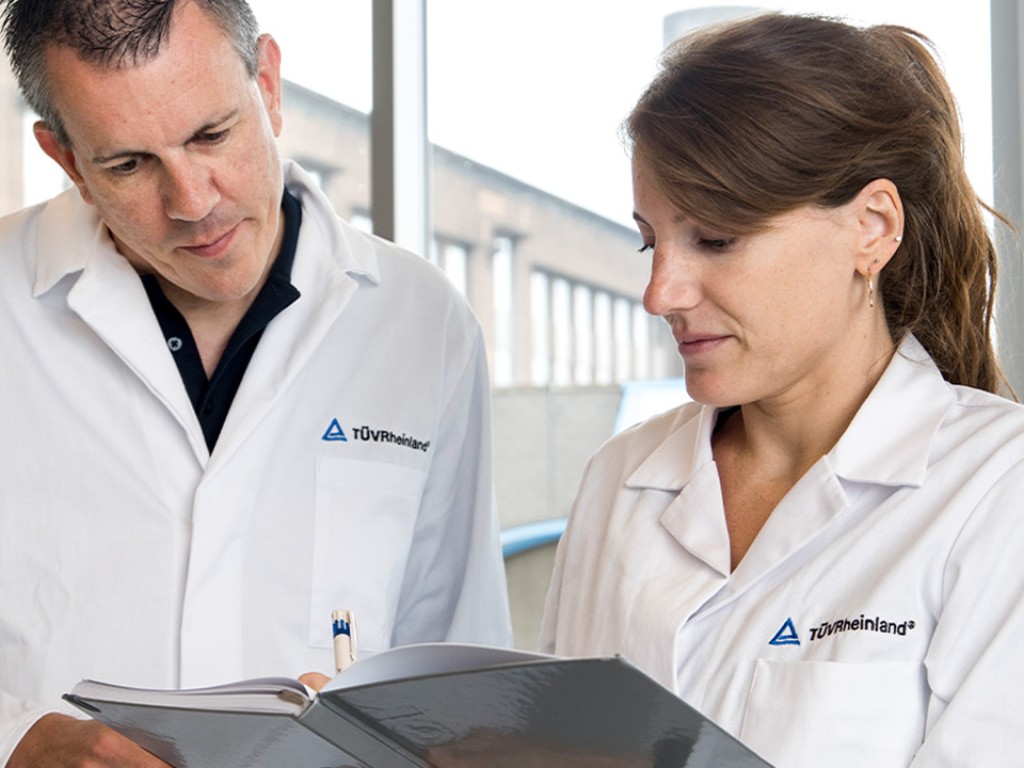 Mann blickt durch ein Mikroskop | TÜV Rheinland