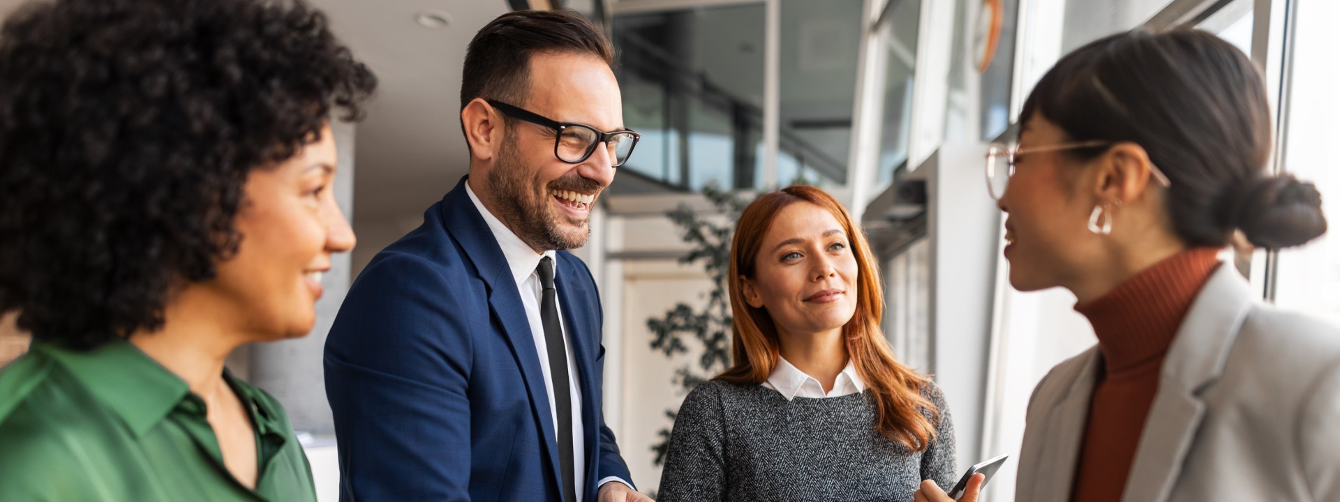 4 Personen die sich unterhalten und dabei anlächeln