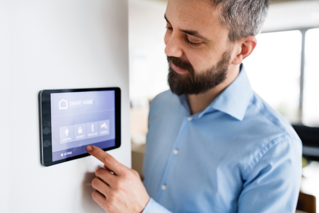 Male at a touch screen using Matter certified smart home technology | TÜV Rheinland