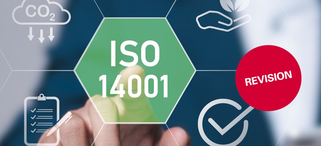 Person using right index finger to point on virtual touchschreen to highlight a green icon saying “ISO 14001”, with red “revision” label.