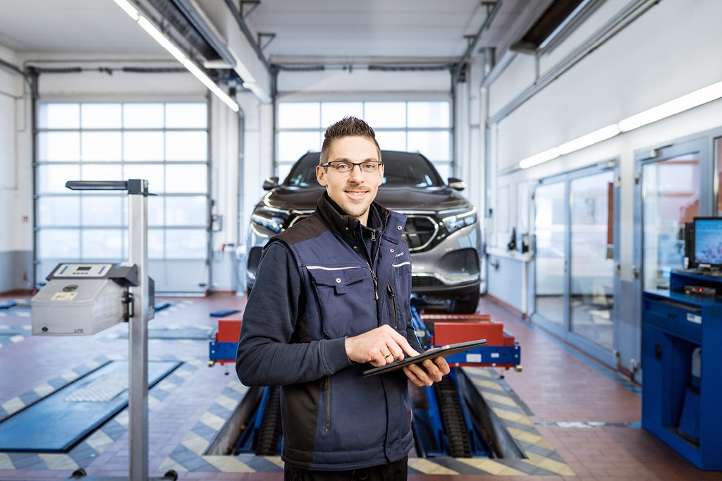 Prüfer dokumentiert Fahrzeugprüfung mit Tablet