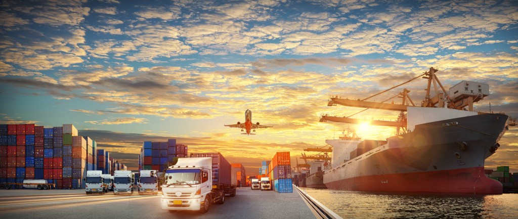 Zdjęcie przedstawia samolot, kontenery, samochody dostawcze, port.