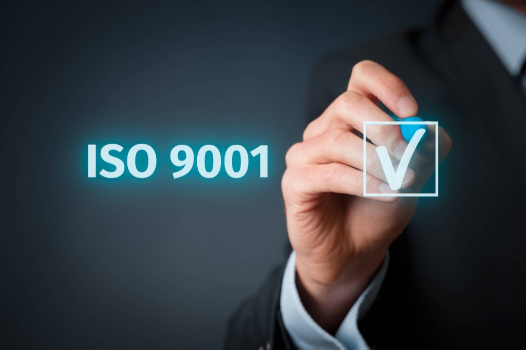 Zdjęcie przedstawia rękę i napis ISO 9001
