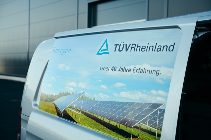 Heck eines Servicefahrzeugs mit Werbung für Solarmodule und erneuerbare Energien