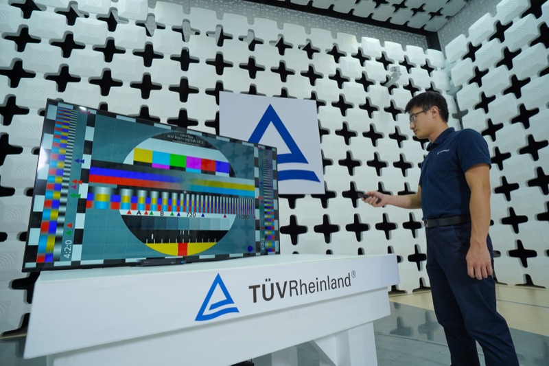 Technician testing a large display screen in an electromagnetic compatibility chamber