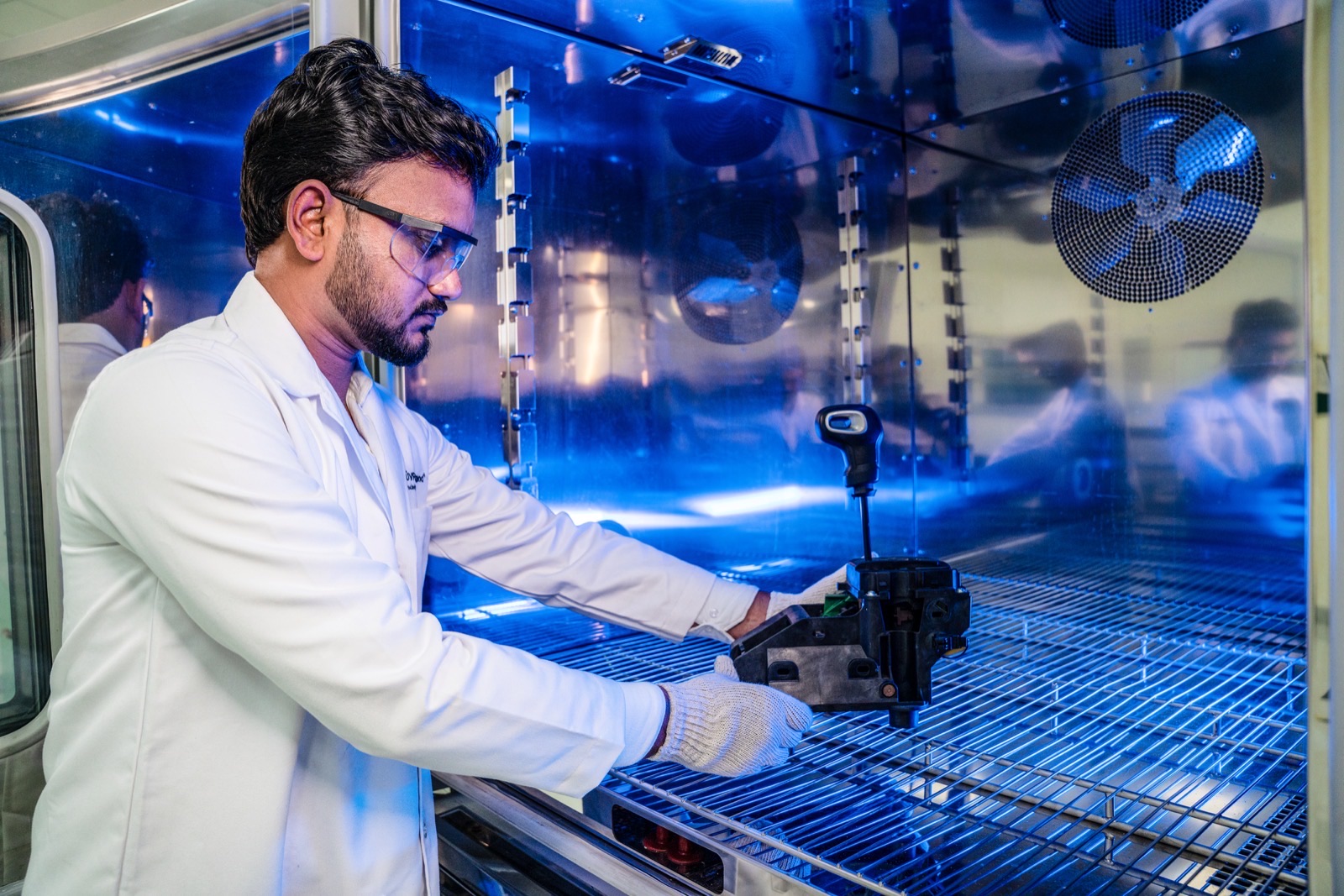Employee during an inspection with materials and testing equipment in a TÜV Rheinland laboratory in the UK